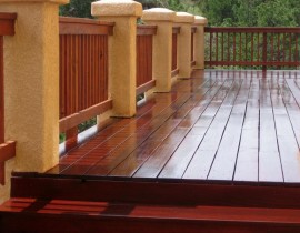 A custom-designed hardwood deck built with Cumaru wood. We added a snow fence railing that is anchored by stucco columns one side of the deck.