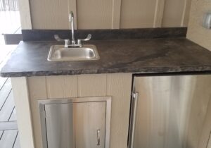 Our customer had us build a mini-kitchen for their covered deck. It includes a fully-functioning sink and mini refrigerator.