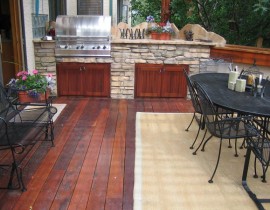 Our customer wanted to add a unique outdoor kitchen area to their Tiger Wood hardwood deck. Using stone, we added a built-in grill with two cabinets below for storage, a countertop for prep work, and a custom backsplash designed to look like the beautiful Rockies.