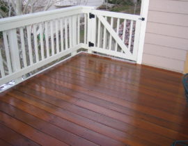This deck features Brazilian Teak or Cumaru decking laid at a 90-degree angle to the joists. We added a redwood snow fence railing with drink cap stained in white.