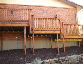 Multi-level snow fence railing in redwood with the balusters mounted on the outside.