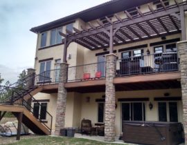This deck incorporates many custom designed and built features - the salvaged wrought iron railing, the stone columns, and the pergola. They all blend to create a beautiful outdoor living space.