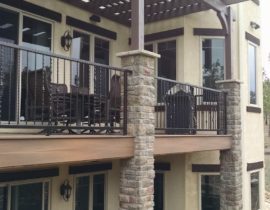 The salvaged and refurbished, custom designed railing perfectly accents the stone columns which are utilized to support the cedar pergola.