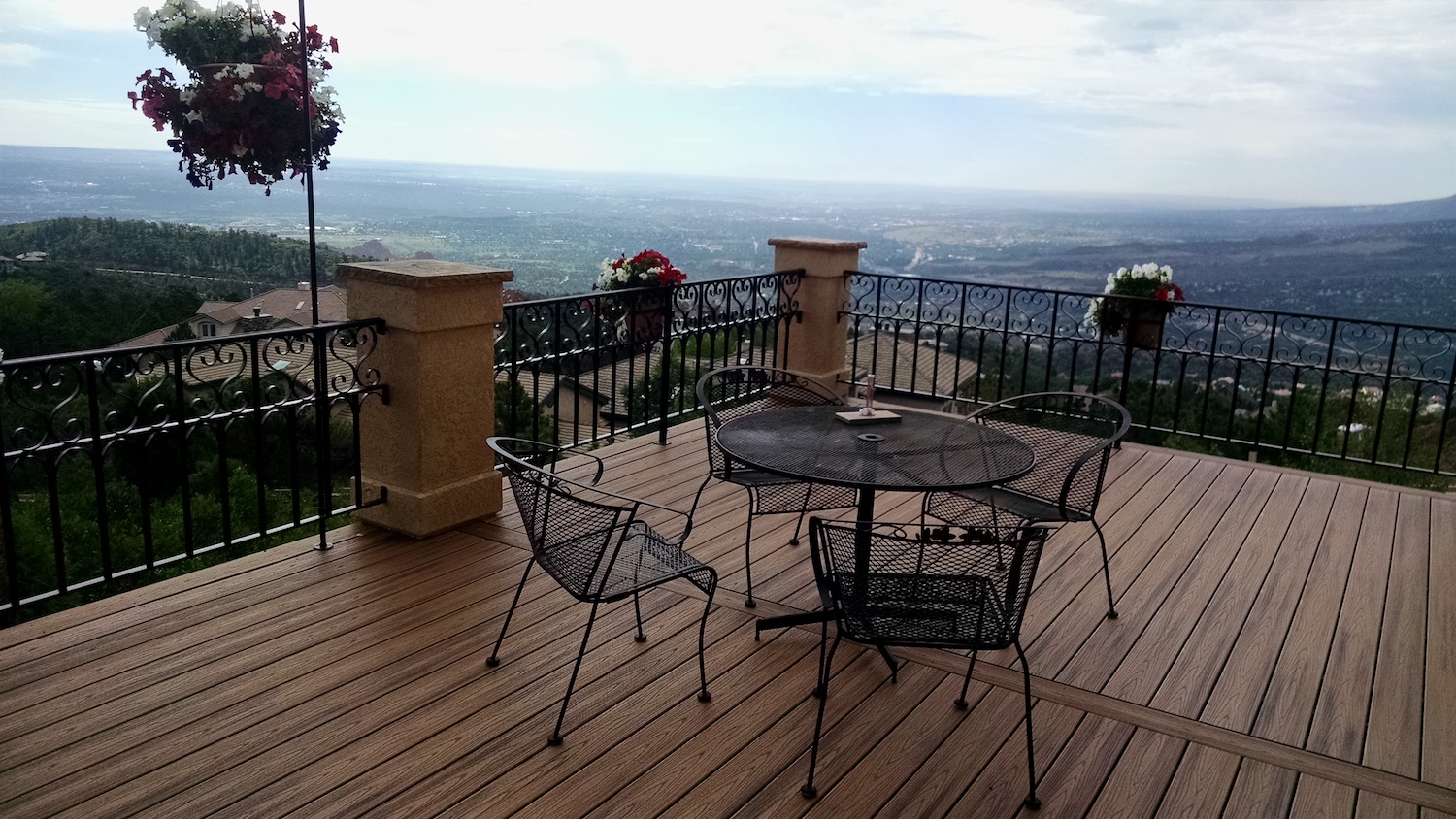Composite deck with stucco columns and custom designed wrought iron railing takes advantages of gorgeous city views.