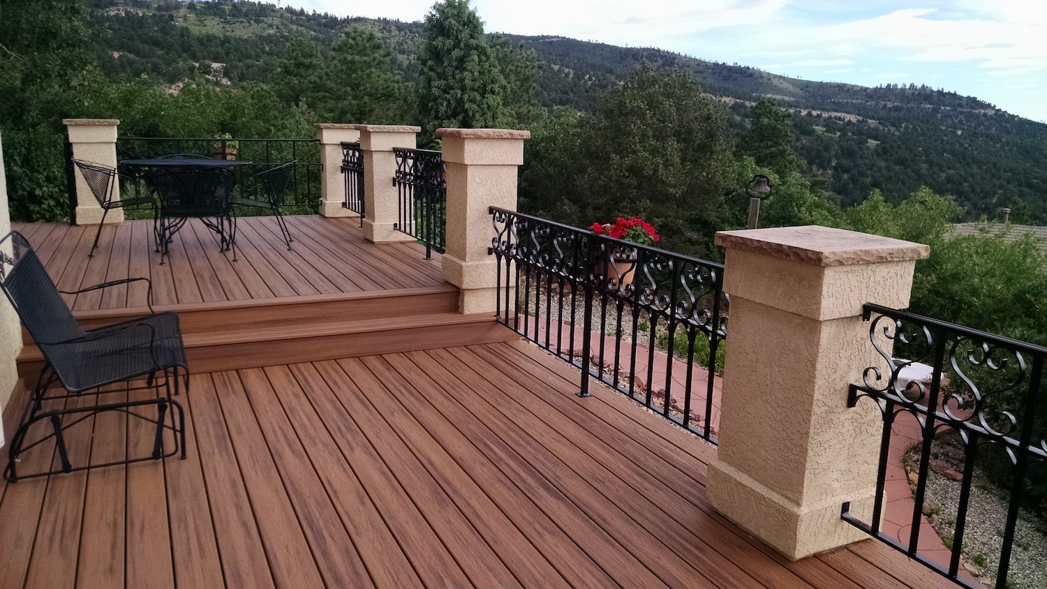 custom designed wrought iron railing supported by stucco columns on a composite deck