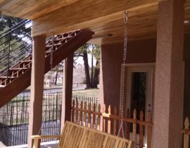 The dry space was installed with a Colorado beetle-kill, tongue and groove Pine ceiling over the steel frame. Stucco columns were built to frame a spot for a swing.