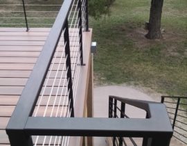 A custom designed metal in oil rubbed bronze and stainless steel cable railing gives the deck a sleek modern look while allowing it to seem more open.