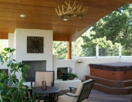 Part of the deck is covered by a large, vaulted, knotty pine tongue and groove ceiling with recessed lighting and an antler chandelier.