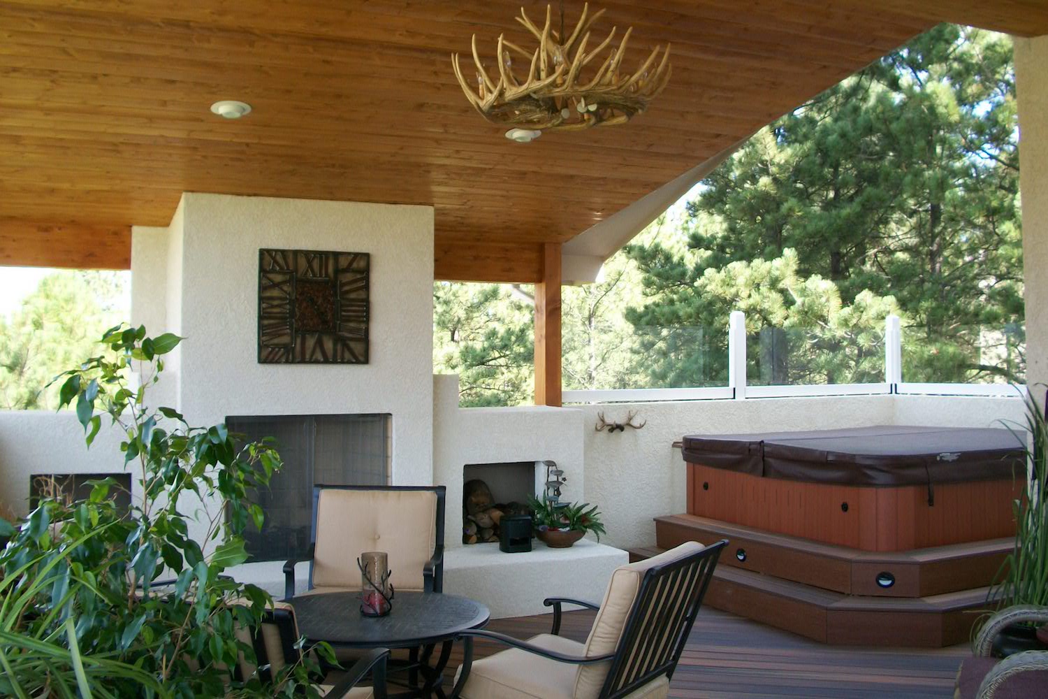 Deck cover with knotty pine vaulted ceiling, antler chandelier, and recessed lighting.