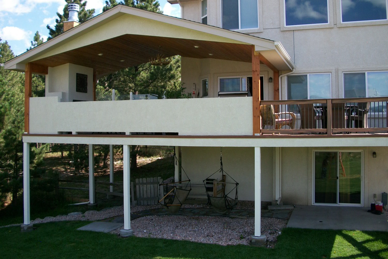 Gabled deck cover over composite deck with outdoor fireplace