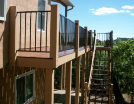 This custom hardwood deck also wraps around the side of the house where there is a flight of stairs going down to ground level.