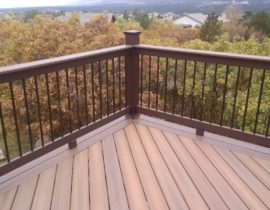 This picture shows the varying shades in the deck boards and the contrast created by the double picture frame in another color. The balusters in the middle of each rail section include a basket design.