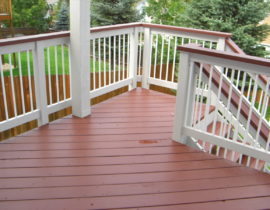 Our customer chose white, round, metal balusters installed in a wood railing. The redwood drink cap is stained a different color than the railing and creates a beautiful contrast.
