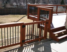 This Redwood railing system has black, metal, twisted-style balusters and a Redwood drink cap. We also installed a matching gate.