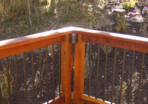 This cylindrical rail light, the Berkley, is installed at the corner of a wood deck, under the drink cap.