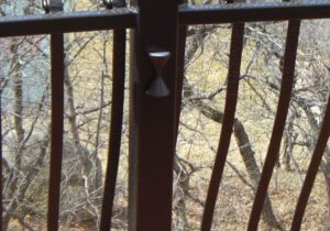 This customer chose a matte black, hour glass shaped rail light to match the custom wrought iron railing.