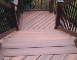 This 4'-wide, closed step staircase features a 180-degree turn landing and wood railing with round metal balusters.