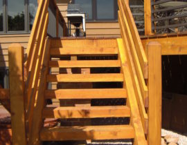 Custom built 4'-wide open staircase with large timber treads and wood railing