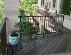 Composite decking laid at a 45-degree angle and a double picture frame. It has a metal panel railing system with basket design balusters.