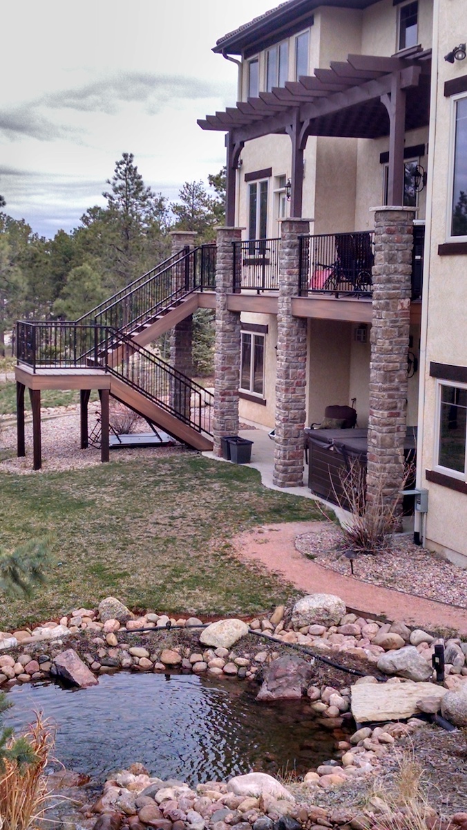 Second story custom deck with pergola and stone columns