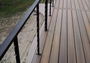 Custom composite deck with custom made metal and stainless steel cable railing