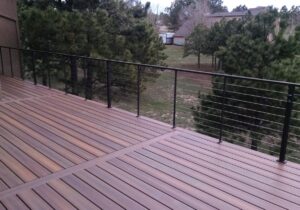 Composite deck with 90-degree boards and a metal and stainless steel cable railing.