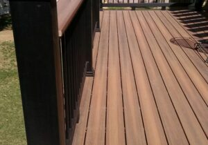 Composite deck with boards laid at 90-degrees and a metal panel railing with composite drink cap.