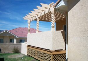 A redwood deck with stucco half-walls and a Cedar pergola stained to match the stucco.
