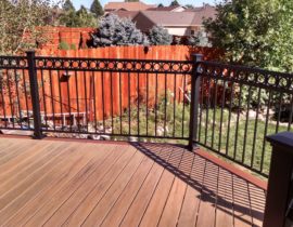 This deck features a single picture frame around 90-degree decking boards. The railing is metal rail panel system with 3x3 posts and a ring, top accent panel added.