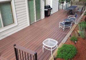 This beautiful backyard is enhanced by a steel framed composite deck. The railing is black metal with a composite drink cap.