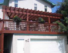 Custom redwood deck with wood railing and pergola.