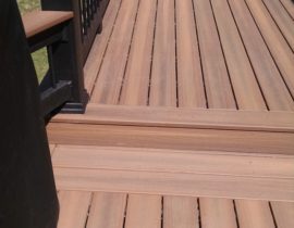The 90-degree angle boards are are bookended by double end boards. The railing features composite components and drink crap with black metal balusters.