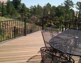 This deck features a double picture frame around 45-degree angle deck board. The railing is a matte black panel system with 2x2 posts.
