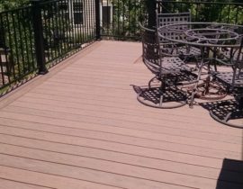 This deck was built with the boards at a 90-degree angle with a double picture frame. The railing is a matte black panel system with 3x3 posts.