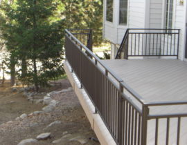 This customer chose a bronze colored, metal panel railing system with a split design top accent panel.