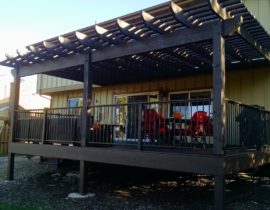 A cedar pergola that is stained to match the composite material used for the deck.