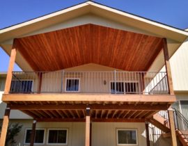 Gabled deck cover with vaulted tongue and groove pine ceiling.