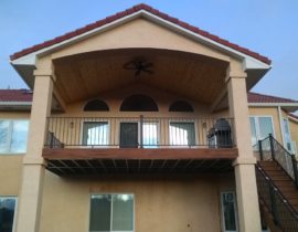 A gabled deck cover with vaulted ceiling in tongue and pine and tile roofing to match the house.