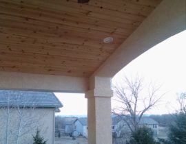 This is a beautiful gabled deck cover in stucco with a vaulted ceiling in tongue and groove pine. It also has recessed lights and a ceiling fan.