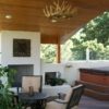 A composite deck with vaulted deck cover, tongue and groove ceiling, stucco fireplace, and hot tub.