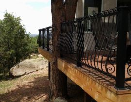 This custom designed wrought iron railing has curli-cue designs on balusters that are located to next to posts to add a personal touch.