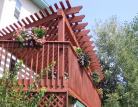 This is a redwood picket fence railing with drink cap stained to match the existing pergola.