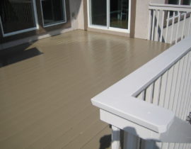 A picket fence railing with drink cap. It has been stained in a white to contrast the deck's tan color.