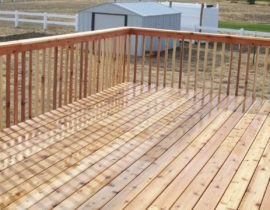 This gorgeous cedar deck features a picket fence railing with drink cap.