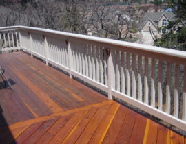 Redwood deck has a snow fence railing with drink cap and lights on the railing posts
