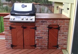 We added a brick-enclosed grill/cooking area with two storage cabinets below. We also added a custom concrete top for a preparation area.