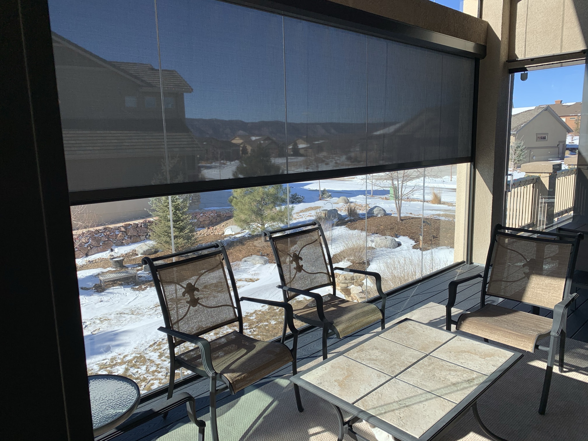 Drop down shades installed in a glass 3-season room allow for privacy