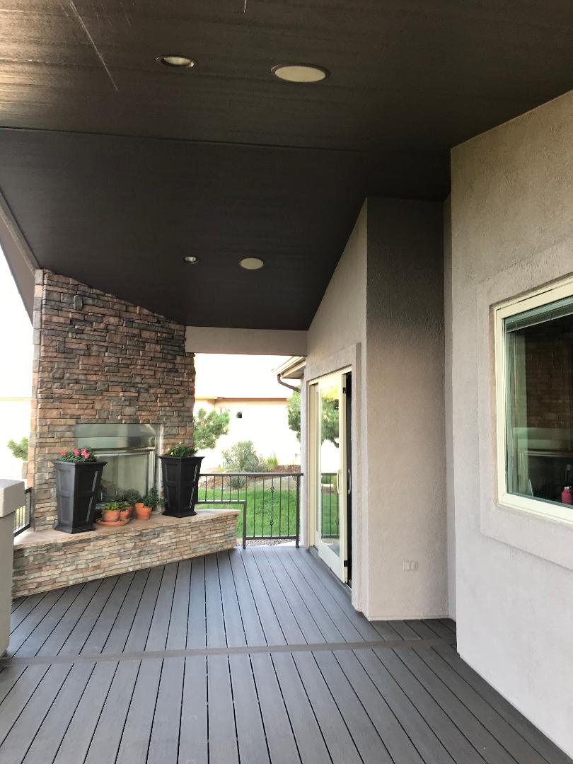 Covered, composite deck with stone gas fireplace