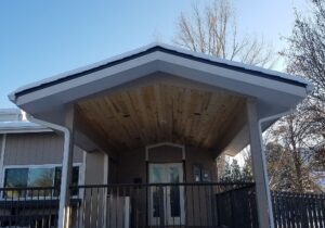 A beautiful gabled deck cover with tongue and groove pine, vaulted ceiling featuring recessed lighting.