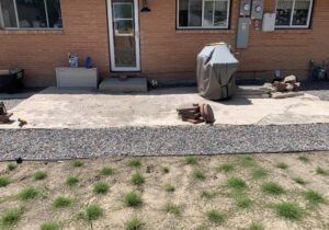 This is a before picture showing the home with a dated, concrete patio in the backyard.